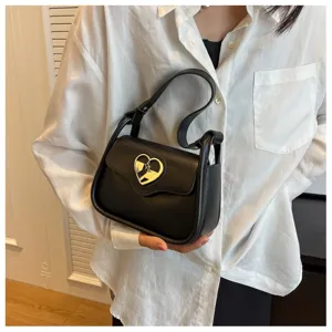 Primo piano della borsa a tracolla nera chic con il suo esclusivo fermaglio in metallo a cuore.