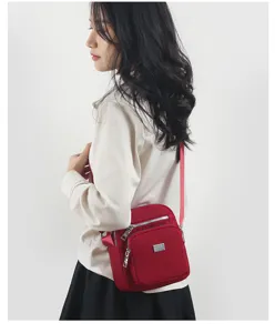 Nylon crossbody bag for women, lightweight multi-layer shoulder bag for travel and daily use.