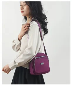 Detailed view of women's multi-layer nylon crossbody shoulder bag, lightweight travel purse.