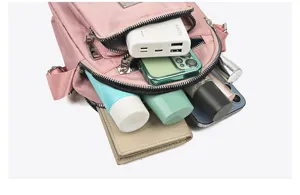 Detail view of the multi-layer nylon crossbody bag showing spacious capacity with items inside.