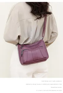 Details of the multi-pocket soft leather shoulder bag showing fine stitching and smooth zippers.