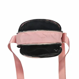 Pink nylon multi-layer crossbody shoulder bag top view showing interior zipper compartments.