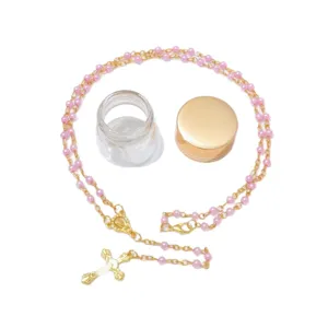 Collana rosario con perle rosa da 4mm, ciondolo croce in lega dorata e bottiglia in vetro.