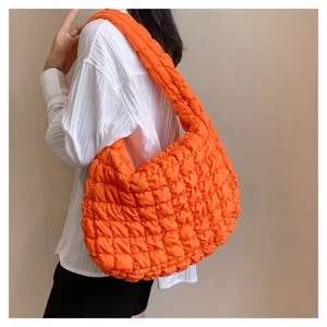 Bright orange quilted puffer shoulder bag for women, trendy large capacity casual tote bag.