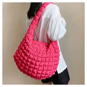 Hot pink puffy quilted shoulder bag, casual large capacity hobo bag detail worn on model.