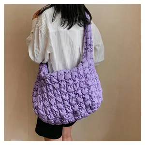 Detail view of purple quilted shoulder bag, showcasing large capacity and soft texture.