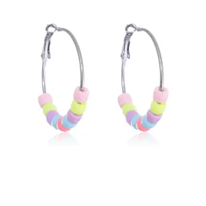 Colorful beaded hoop earrings, candy color small metal circles fashion jewelry detail shot.