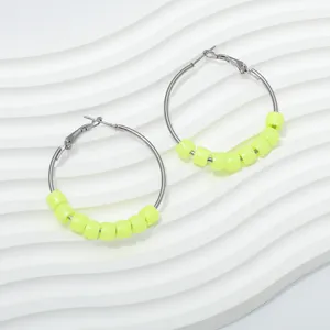 Detailed view of neon yellow beaded hoop earrings featuring gun black metal rings close up.