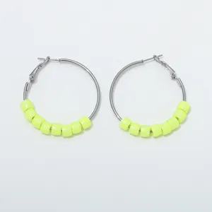 Detail view of trendy neon yellow beaded hoop earrings with sleek gunmetal finish.