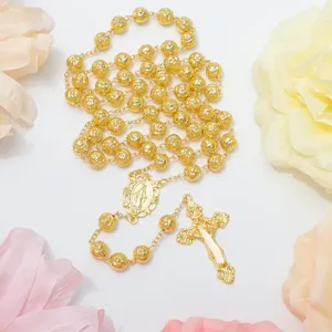 Primo piano collana rosario oro, dettaglio sfondo floreale, gioielli religiosi.