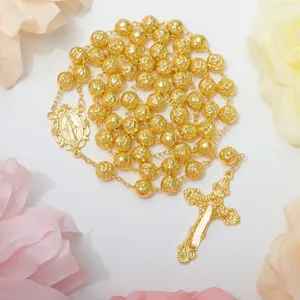 Dettaglio collana rosario croce perle di rosa vintage dorata, gioielli religiosi.