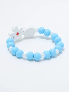 Detail van blauwe kralen armband met witte bloem hanger en kleine parels voor kinderen.