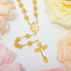 Collana con perline rosario dorate con ciondolo crocefisso e design floreale elegante.