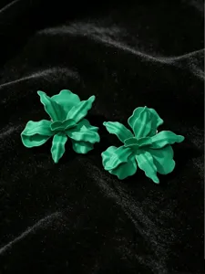 Gedetailleerde close-up van groene metalen bloemoorringen met een gelakte afwerking.