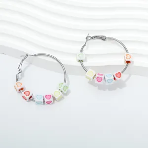 Close-up detail of stylish hoop earrings featuring colorful heart pattern cube beads nicely.