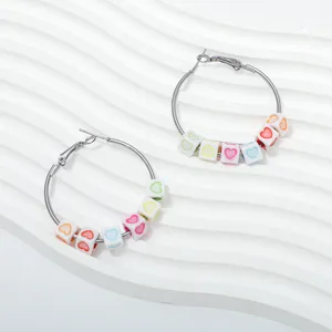 Detail shot of colorful heart cube beads on a silver hoop earring, highlighting the chic design.