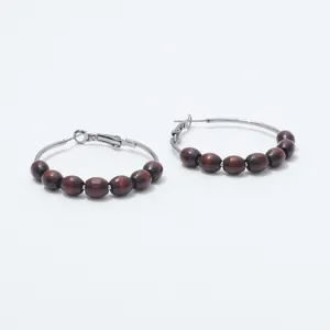 Detail view of vintage wooden bead hoop earrings featuring smooth brown beads on metal rings.