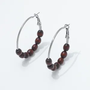 Close-up detail of vintage wooden beaded hoop earrings with silver metal wire design.