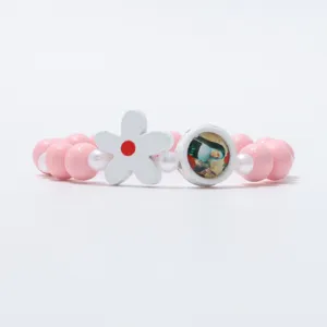 Charmante roze kralen armband met witte bloem en portret hanger elastisch voor kinderen.