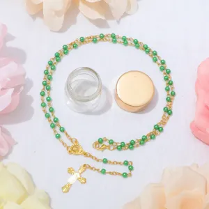 Elegante collana con rosario di perle verdi con crocifisso in lega d'oro e bottiglia di vetro.