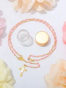Vista dettagliata della collana rosario di perle rosa da 4 mm con ciondolo a croce e bottiglia.