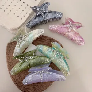 Close-up of resin starfish hair claws featuring sparkling rhinestones in assorted colors.
