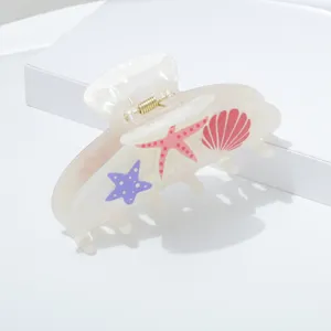 Close-up detail of white marine style hair claw clip featuring cute starfish and shell patterns.