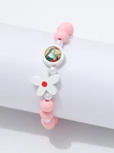Detail van roze houten kralen armband met bloemhangertje en religieus medaillon