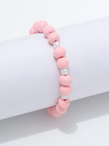 Gedetailleerde foto van roze houten kralen en witte parel elastische armband, simpele sieraden.
