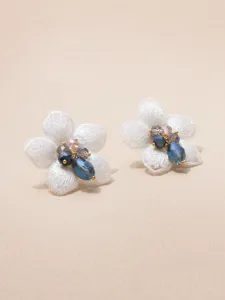 Close-up detail van elegante witte mesh bloem oorbellen met sprankelende kristal kralen.