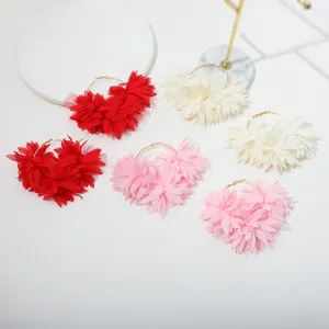 Chiffon bloem creolen detail opname, handgemaakte gelaagde bloemblaadjes, elegante stijl.