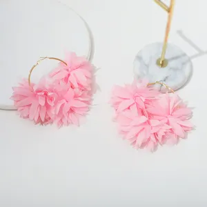 Gedetailleerde opname van roze chiffon bloem oorbellen met prachtig gelaagde bloemblaadjes.
