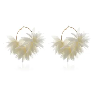Gedetailleerd opname van elegante witte chiffon bloem oorringen met stoffen blaadjes.