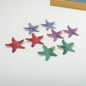 Colorful rhinestone starfish earrings details, sparkling crystal sea star studs closeup display.