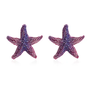 Close-up detail of gradient purple rhinestone starfish earrings, sparkling crystal studs.