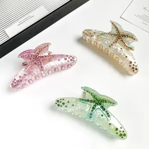 Detailed view of resin starfish hair claw with sparkling rhinestones, elegant large shark clip design.