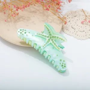 Mint green starfish resin hair claw clip featuring sparkling green rhinestones, detail.