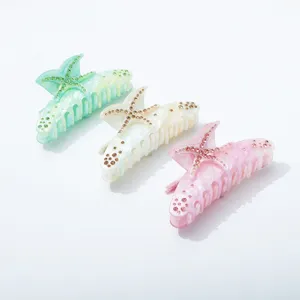 Detail shot of acrylic starfish hair claw clip, rhinestone embellished shark hair clip.