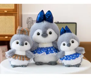 Conjunto de peluche de pingüino gris lindo con faldas de cuadros y lazos brillantes.