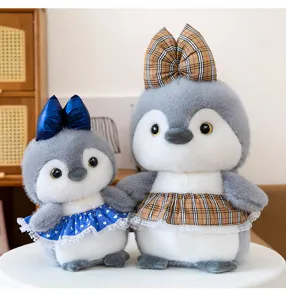 Vista detallada de lindos muñecos pingüino de peluche con vestidos a cuadros, juguete suave.