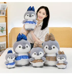 Adorable muñeco de peluche de pingüino con faldas de cuadros y corazones, vista de detalle.