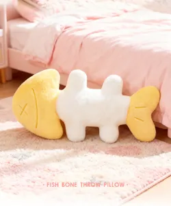 Detailed shot of cute fish bone throw pillow in pink bedroom scene, soft plush material.