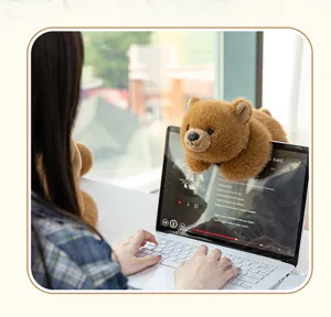Simpatico orsetto di peluche marrone appeso allo schermo del laptop, morbido regalo.