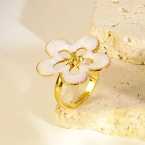Bague élégante en acier inoxydable plaqué or avec un design de fleur en émail blanc.