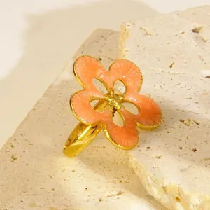 Bague fleur en acier inoxydable émaillé, design floral rose pêche élégant avec bordure dorée.