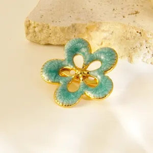 Élégante broche fleur en acier inoxydable et émail, design floral chic de luxe français pour femmes.