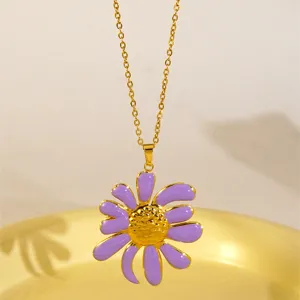 Primo piano dettagliato di una collana con ciondolo a fiore in smalto viola e acciaio dorato.