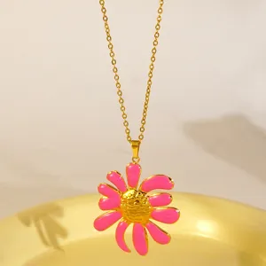 Primo piano della collana con ciondolo a fiore smaltato rosa e catena placcata in oro dettaglio.