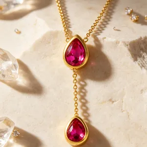 Close-up detail of the 18k gold plated stainless steel teardrop pendant necklace with pink stones.