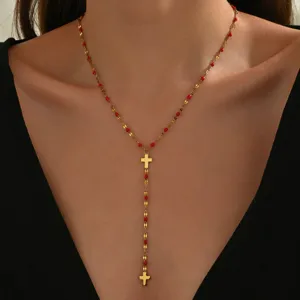 Collana a Y con croce in oro e perline smaltate rosse, catenina in acciaio titanio 18k.